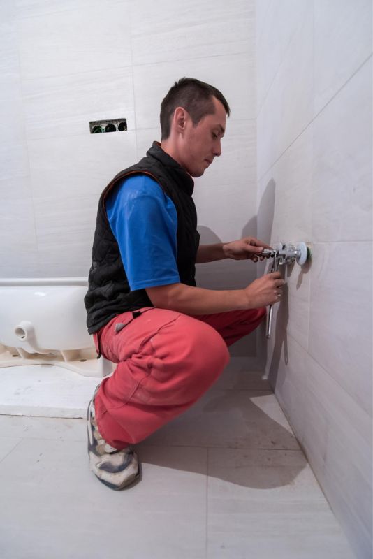 Un plombier répare une urgence dans la salle de bain.